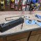 Below the calipers is the old PCV adapter, sitting next to the PCV valve and its grommet. Above the calipers is a metal disc, which is the body of the baffle to be installed.